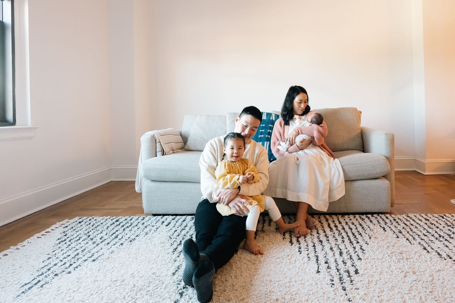 Candid family moments captured on white carpet during indoor photoshoot.