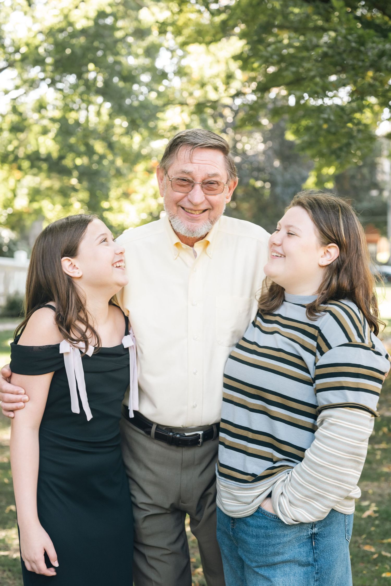 Candid family photos showing joyful laughter and embraces in an outdoor setting.