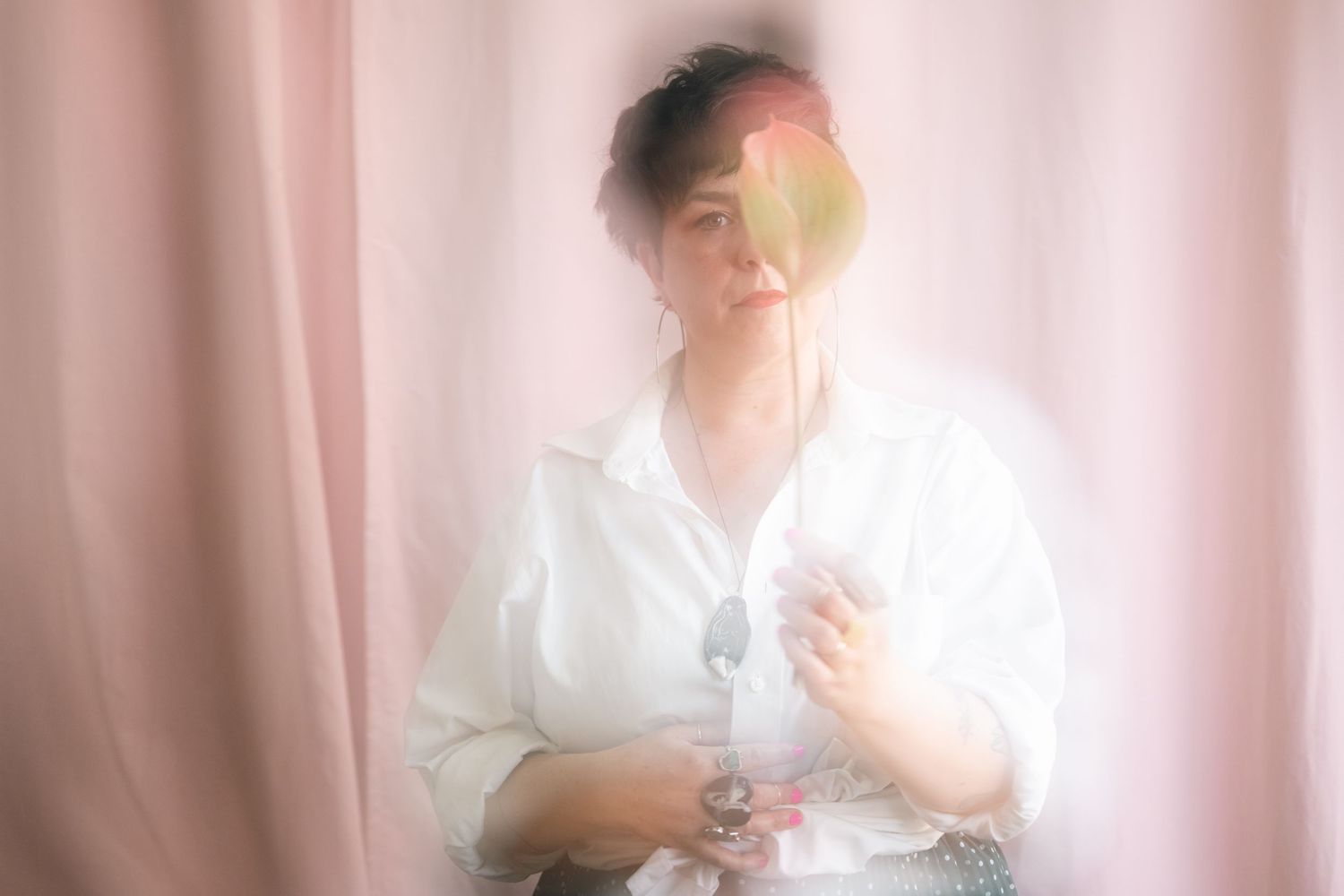 Ethereal portrait series with soft pink curtains creating a romantic and dreamy mood.
