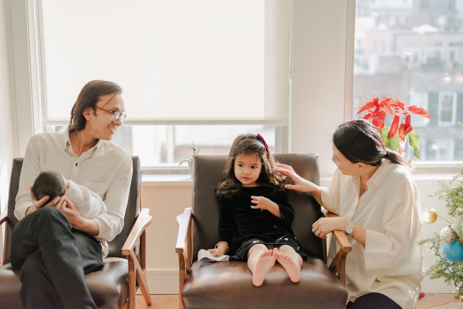 Candid lifestyle photography session showing family bonding moments near bright windows.