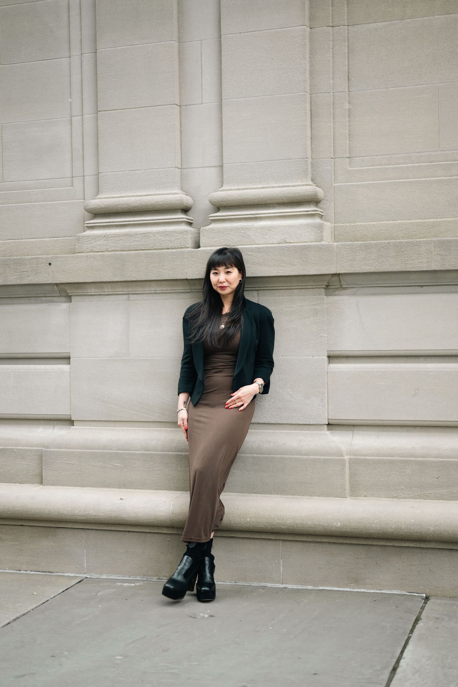Fashion portrait against white architectural columns and steps.