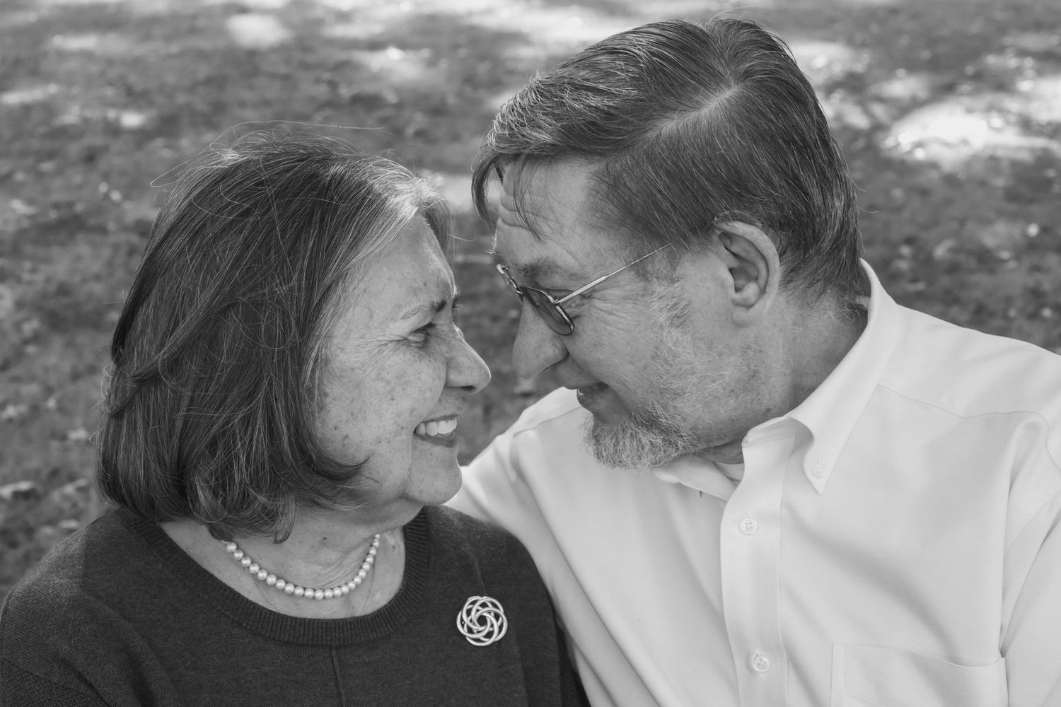 Romantic couple photos in black and white showing tender moments in an outdoor setting.