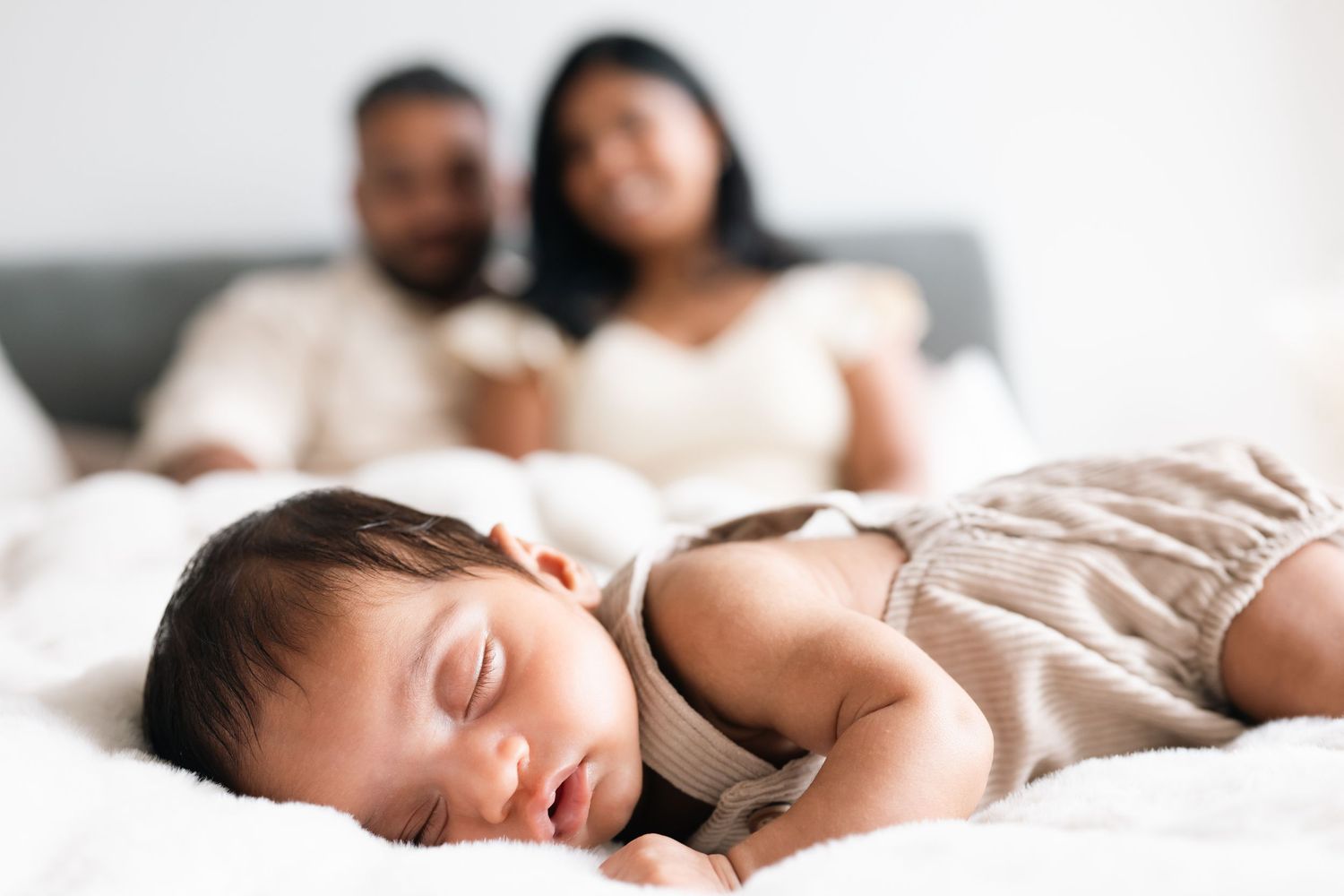 A peaceful scene of someone sleeping soundly in white bedding with soft natural light coming through.