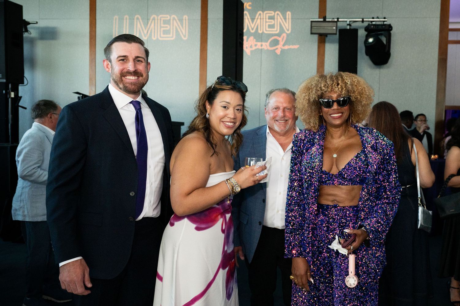 Four guests smile together at the LUMEN IESNYC After Glow gala event, dressed in elegant formal attire.
