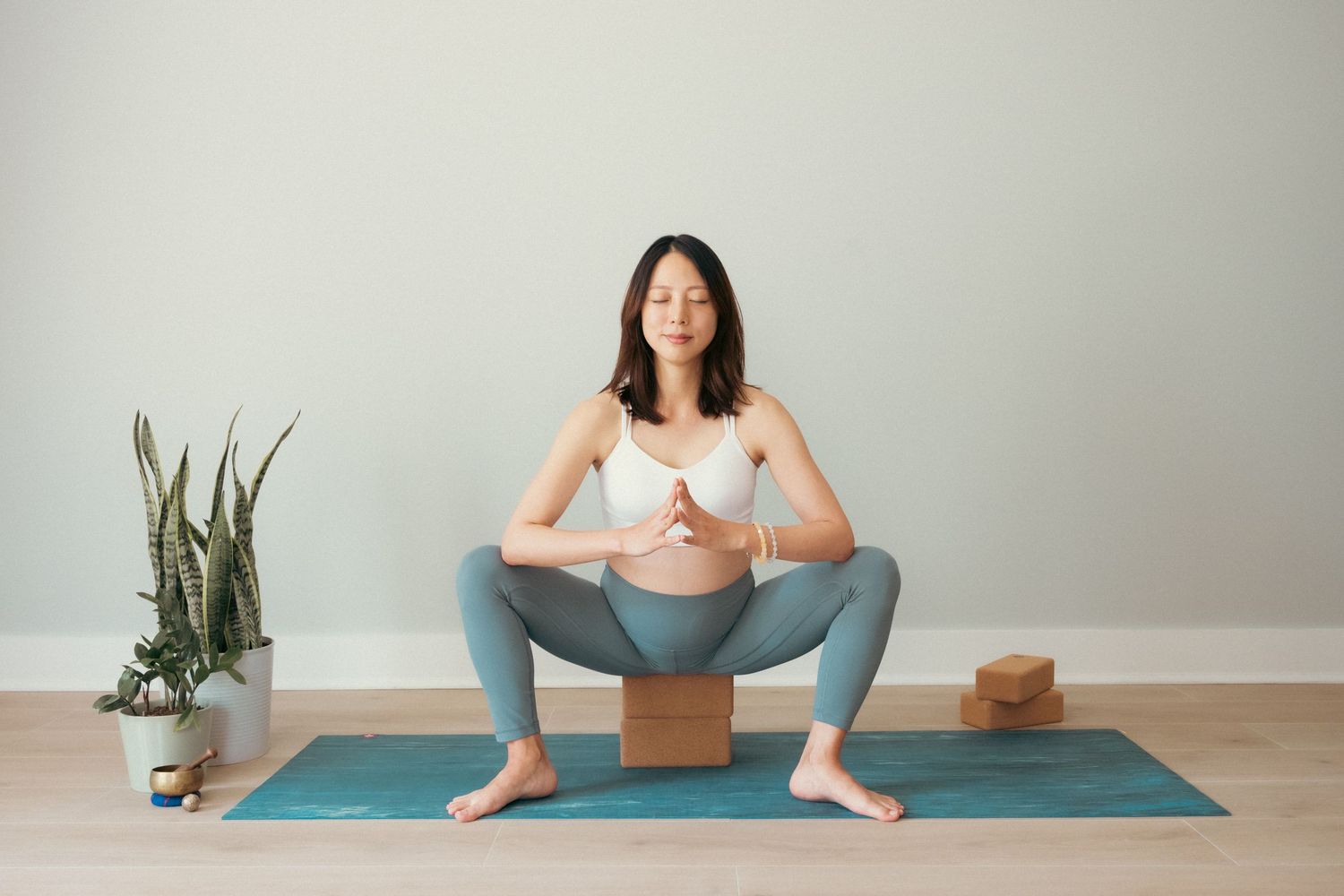 Yoga sequence showing seated poses and stretches on a blue exercise mat with props.
