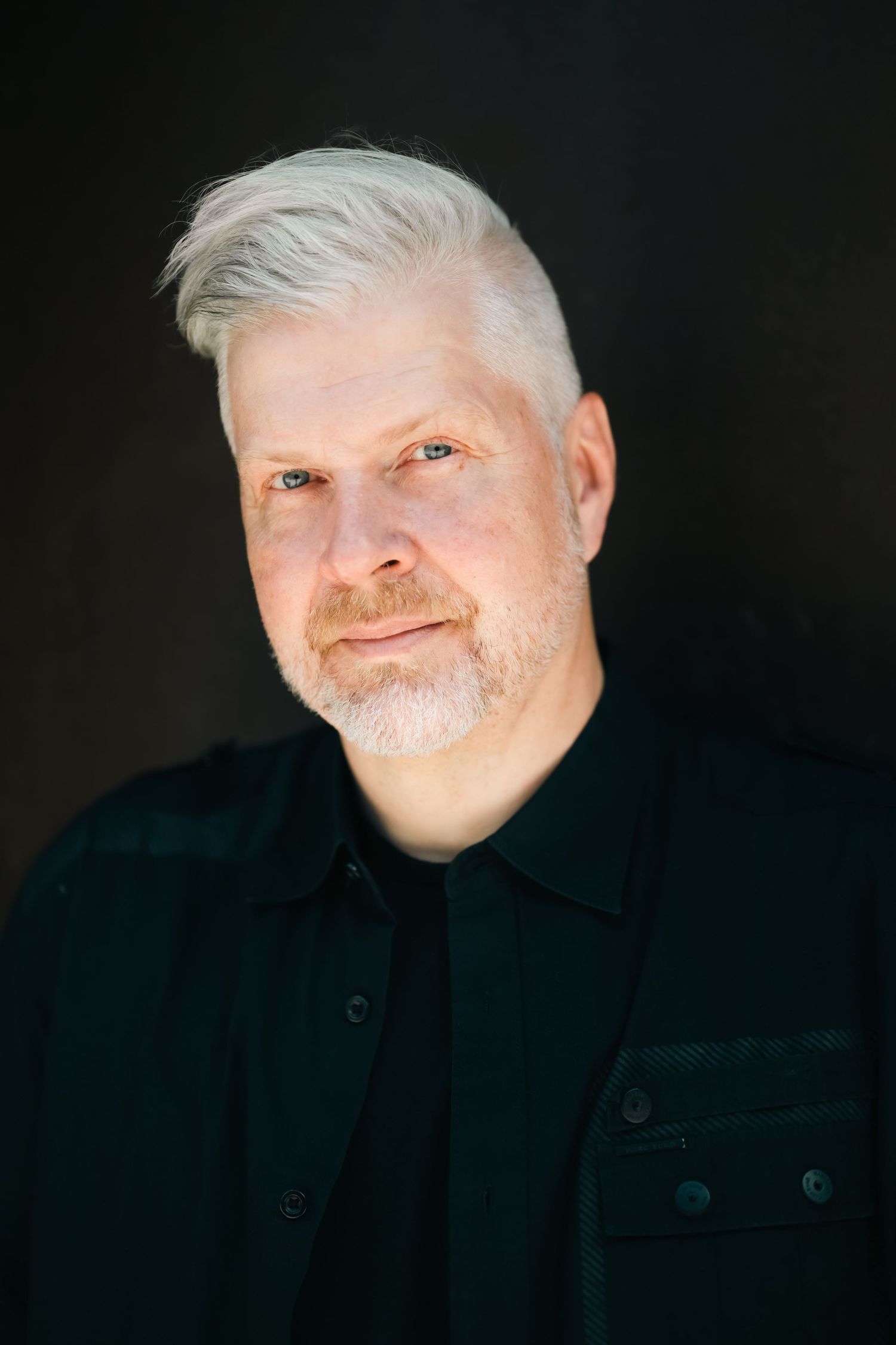 Studio portrait series with dramatic lighting against dark background.