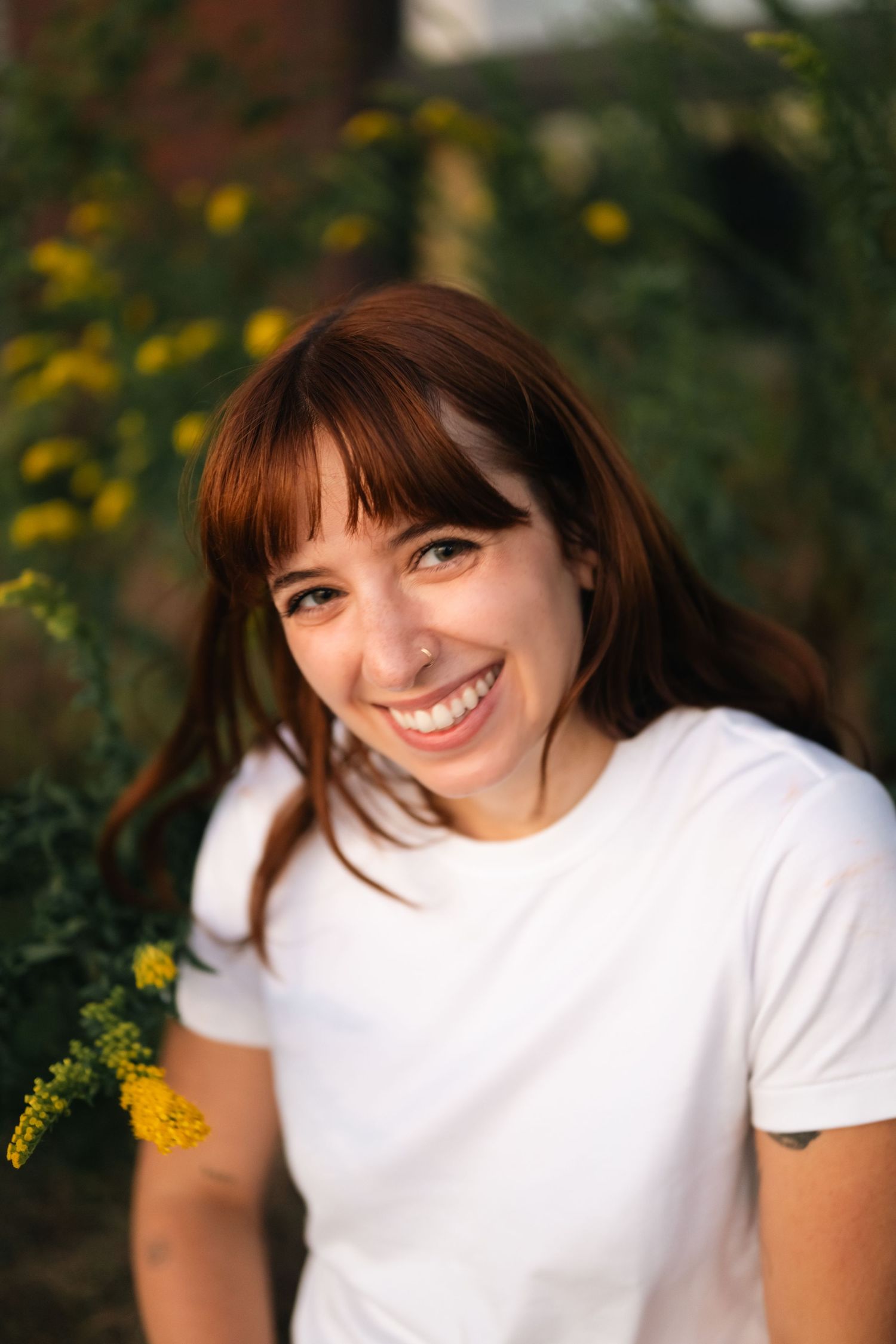 Portrait series against yellow flowers and greenery in natural outdoor lighting.