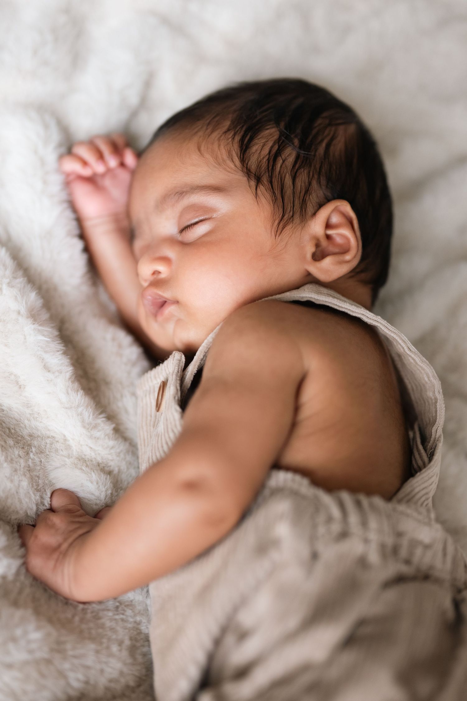 Peaceful sleeping baby wrapped in soft white blankets shown from multiple angles.
