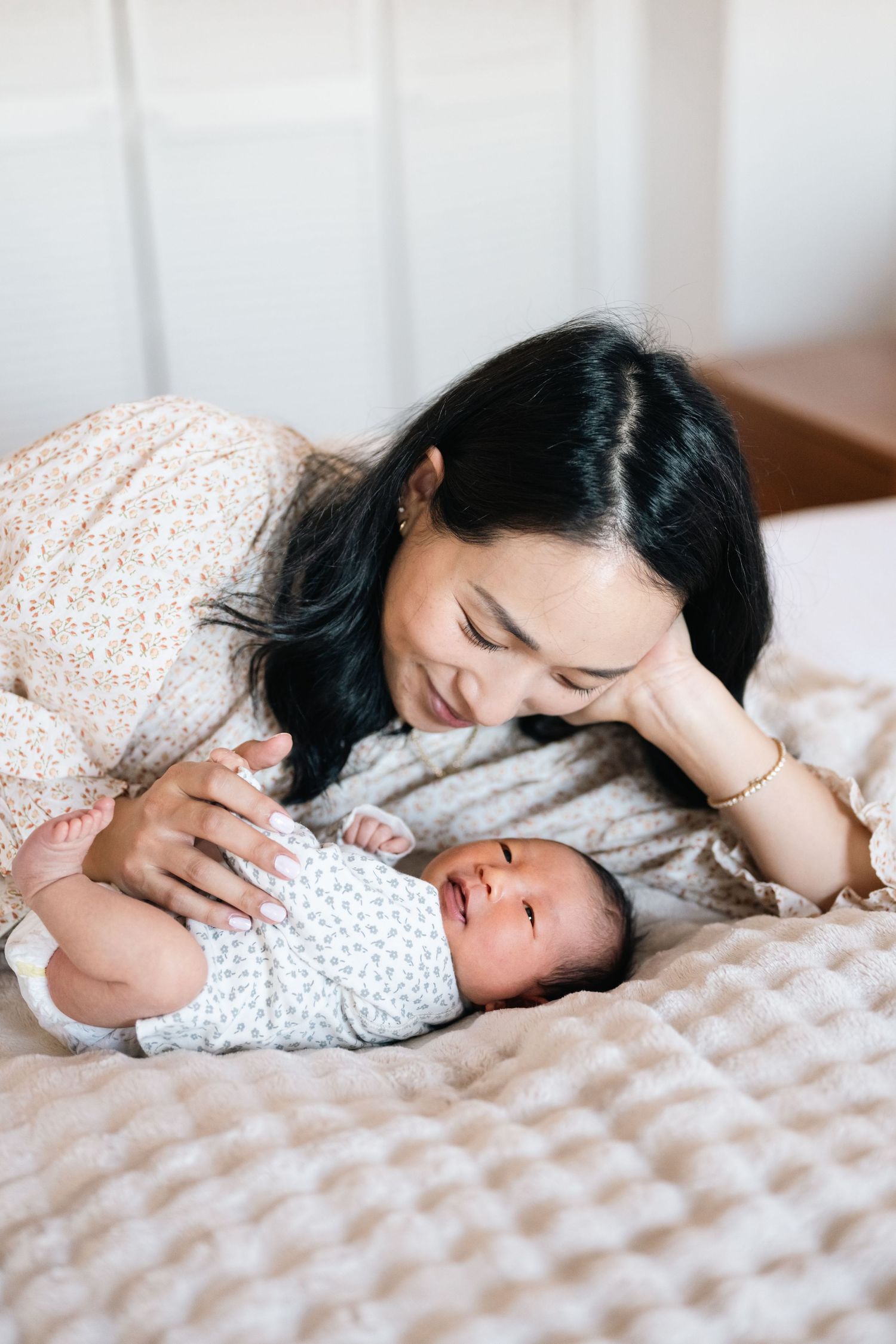 Intimate bonding moment between parent and newborn on soft bedding.