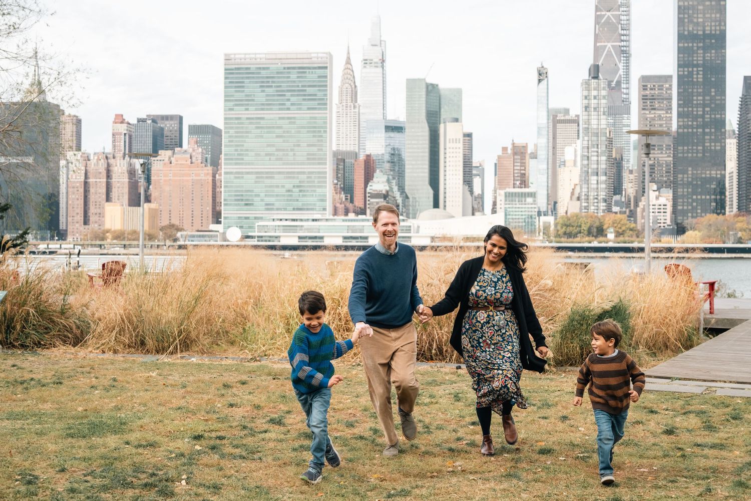 Family walking together against New York City skyline backdrop.