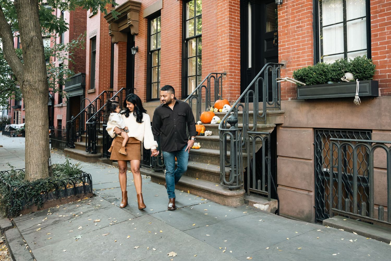 Series of brownstone building stoops and entryways along a city street.