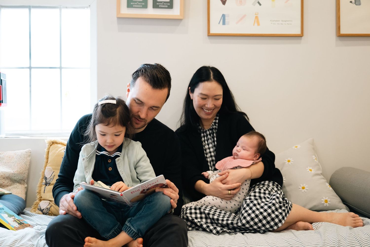 An intimate indoor family portrait session with a newborn baby in a bright, modern living room.