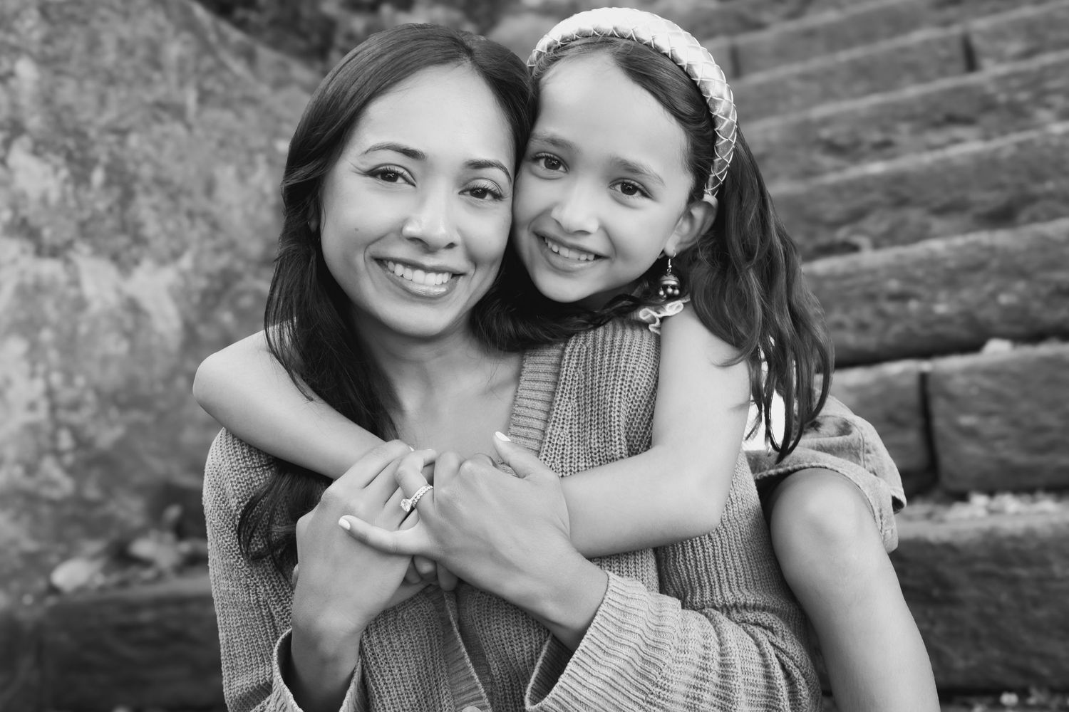 Black and white photo collage showing warm embraces and candid moments between loved ones in outdoor settings.