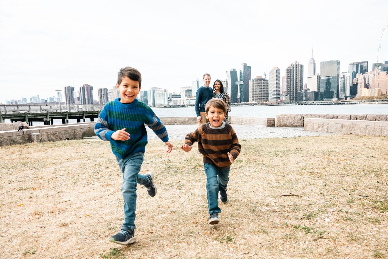 Children running and playing in an open field with Toronto skyline visible.