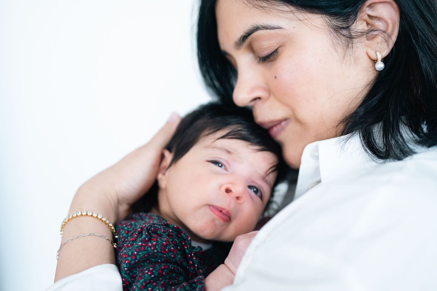 A tender moment of a mother cradling her newborn baby, both sharing a peaceful and loving embrace.
