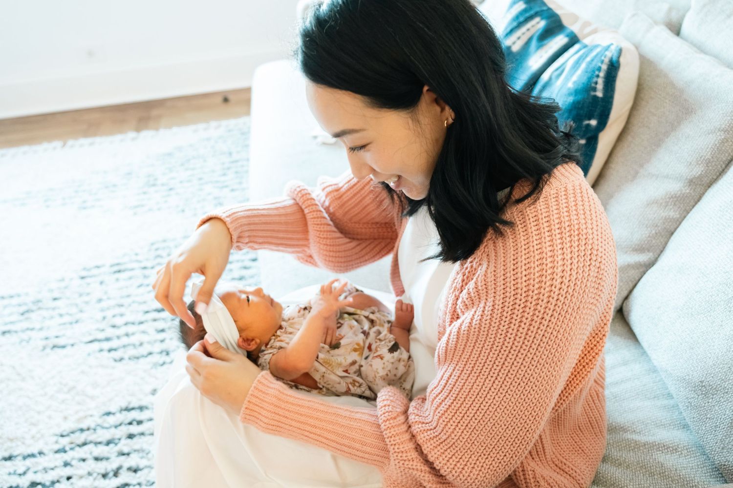 Mother in pink sweater sharing tender moments with baby.