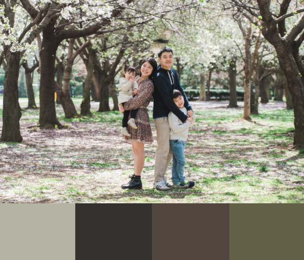 Family spending time together under blooming trees in a peaceful park setting.