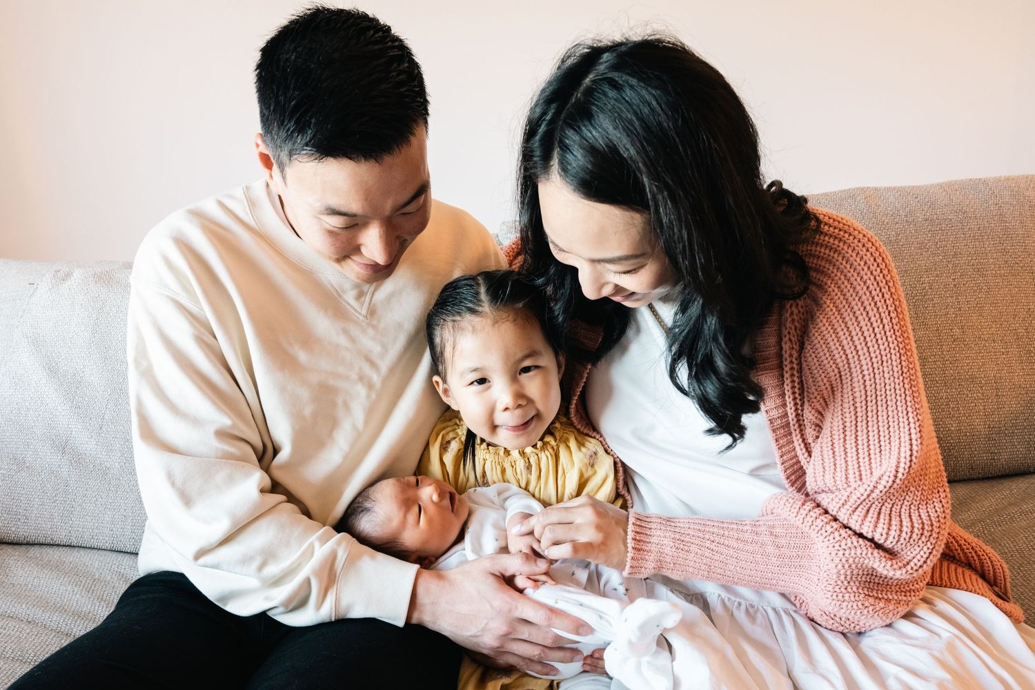 Family relaxing together on cozy couch during lifestyle photo session.