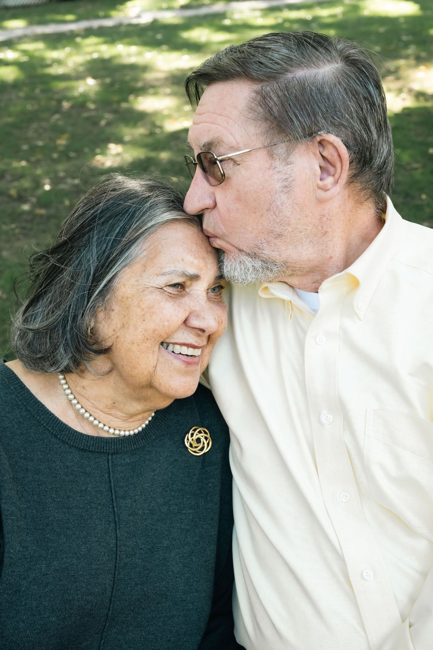 Senior couple sharing affectionate moments in a series of candid outdoor portraits.