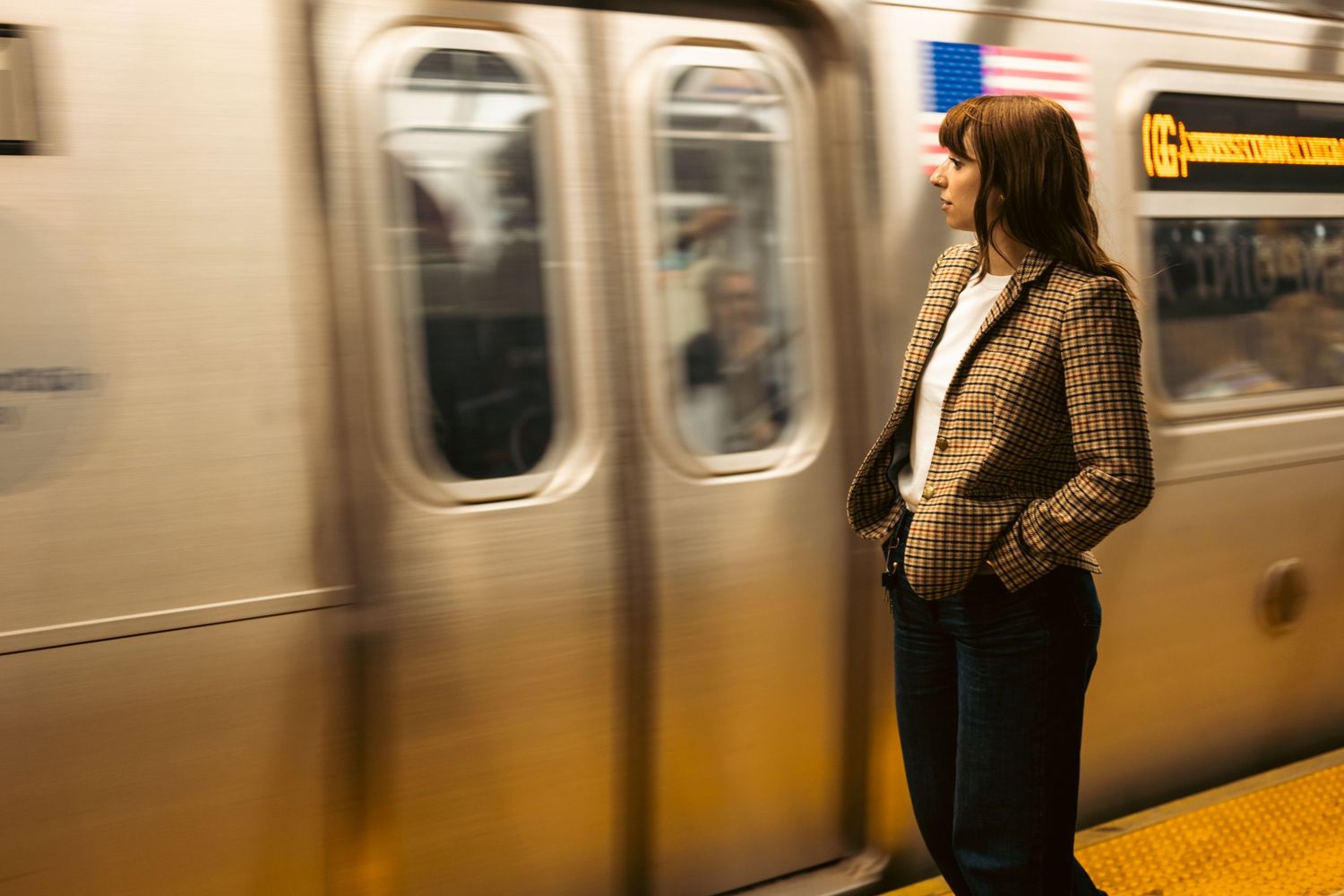 Urban subway station scene with motion-blurred train and figure in casual attire.