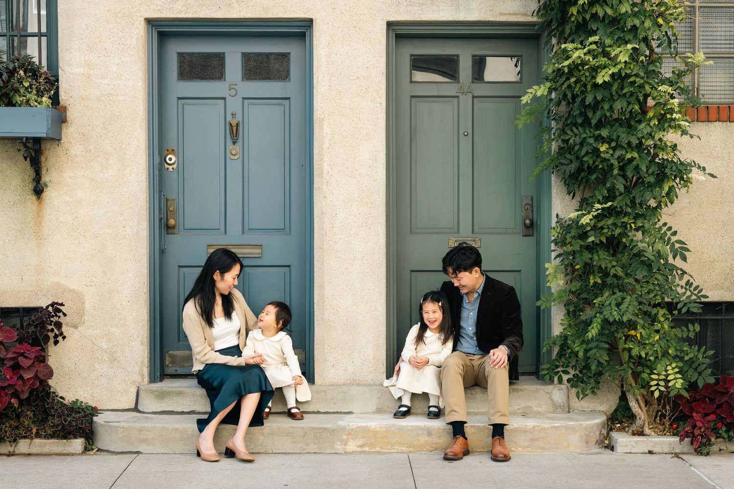 A sequence of tender family moments captured against a building with blue-green doors.