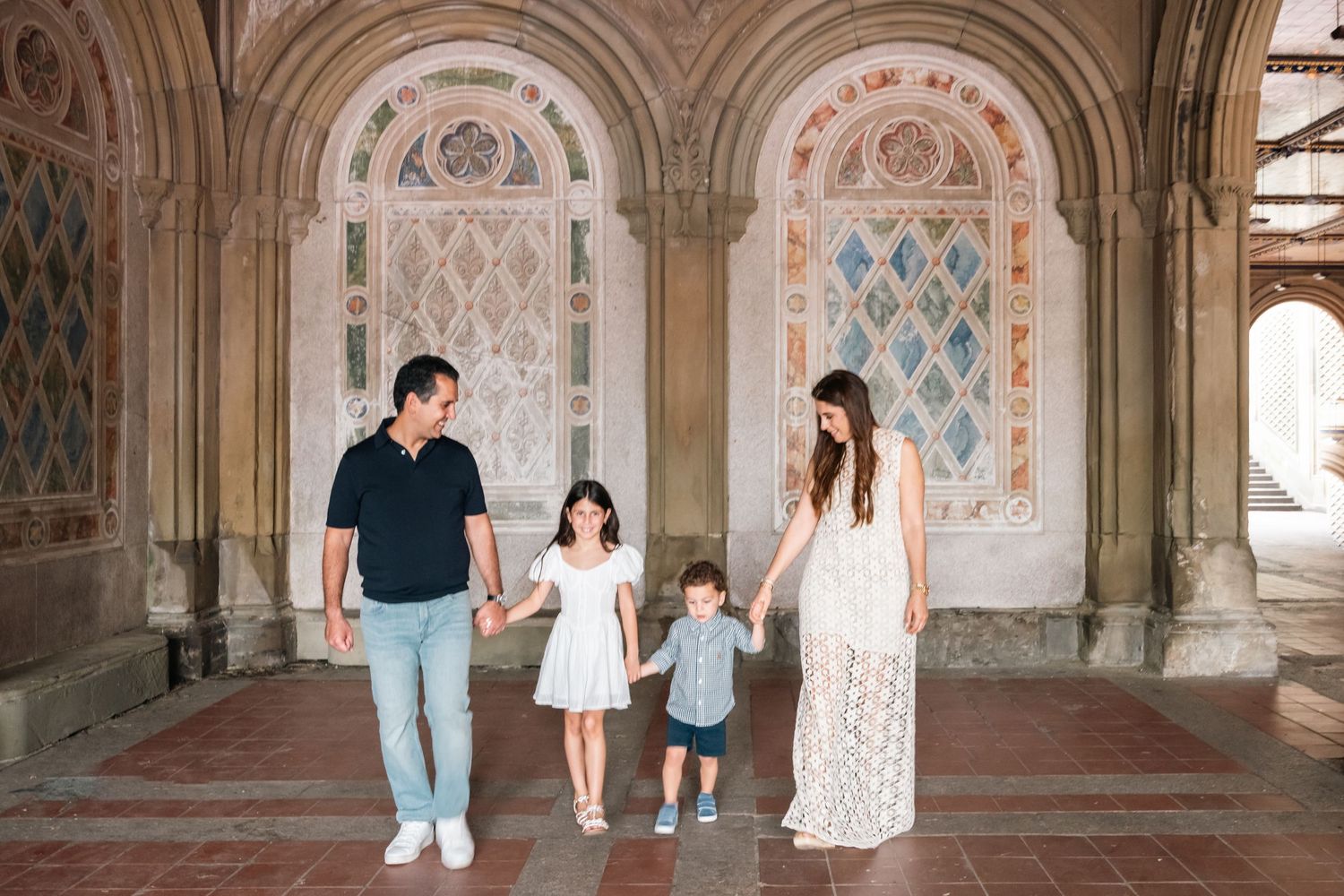 Candid family moments captured under ornate architectural arches in a historic building.
