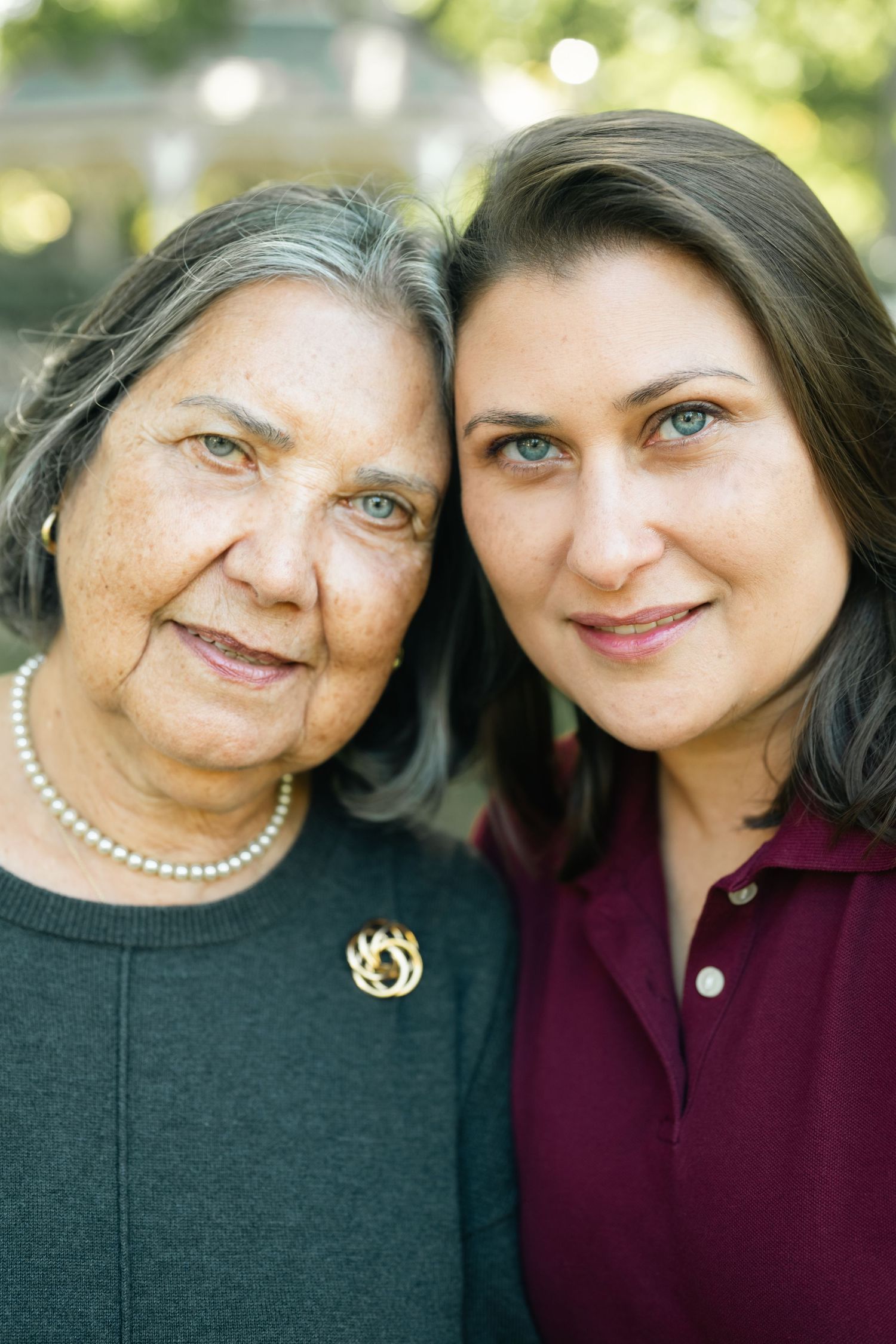 Close-up portrait of two people leaning in together with warm smiles.