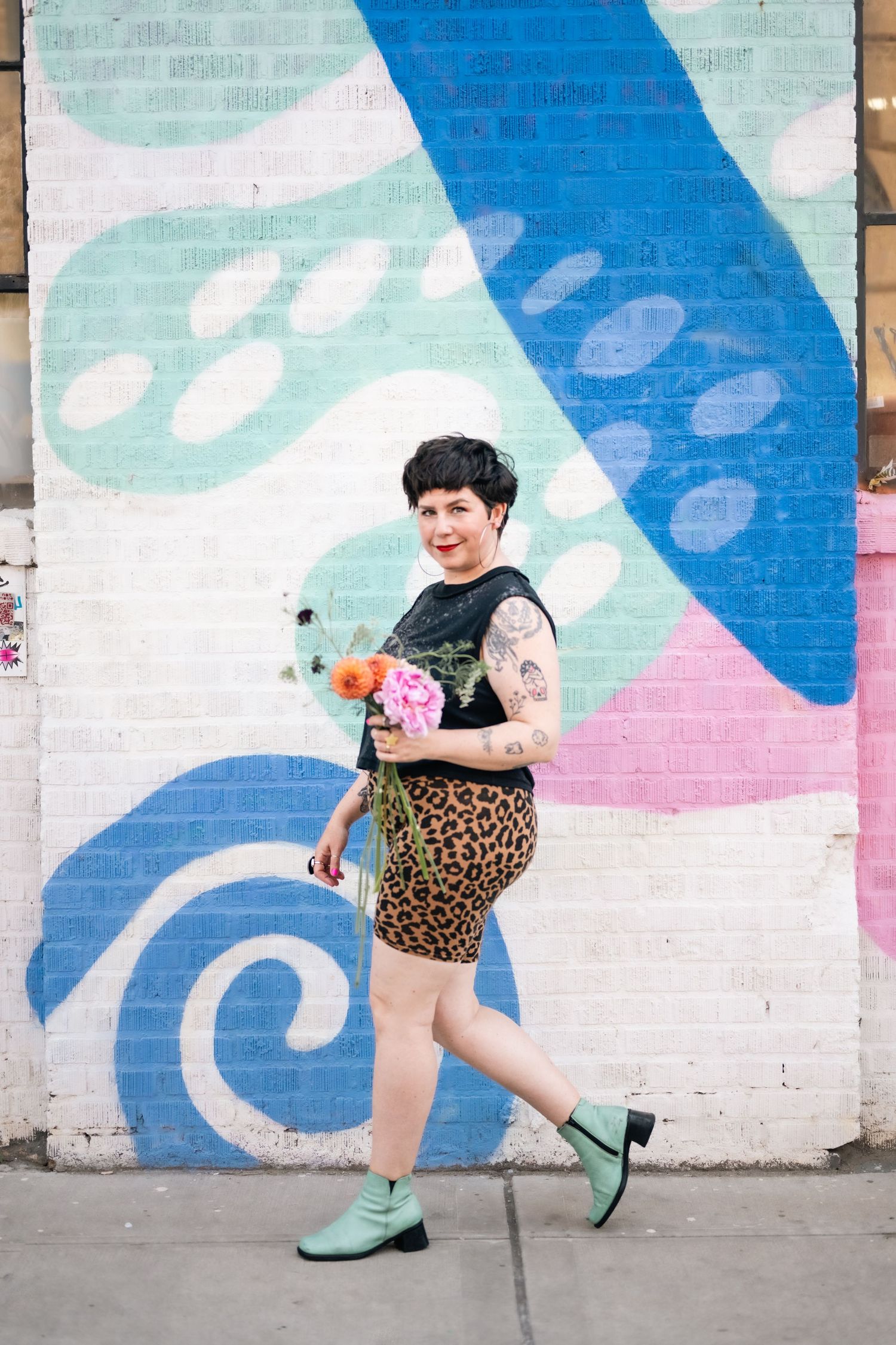 Dynamic poses in leopard print against a vibrant geometric wall mural.
