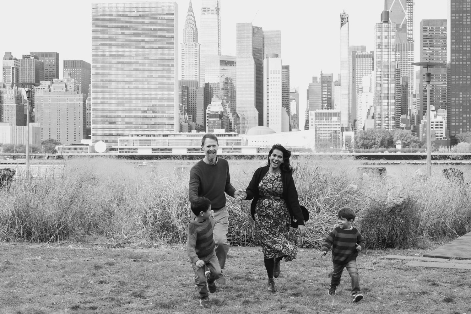 Family silhouettes against Manhattan skyline with tall buildings and urban landscape.
