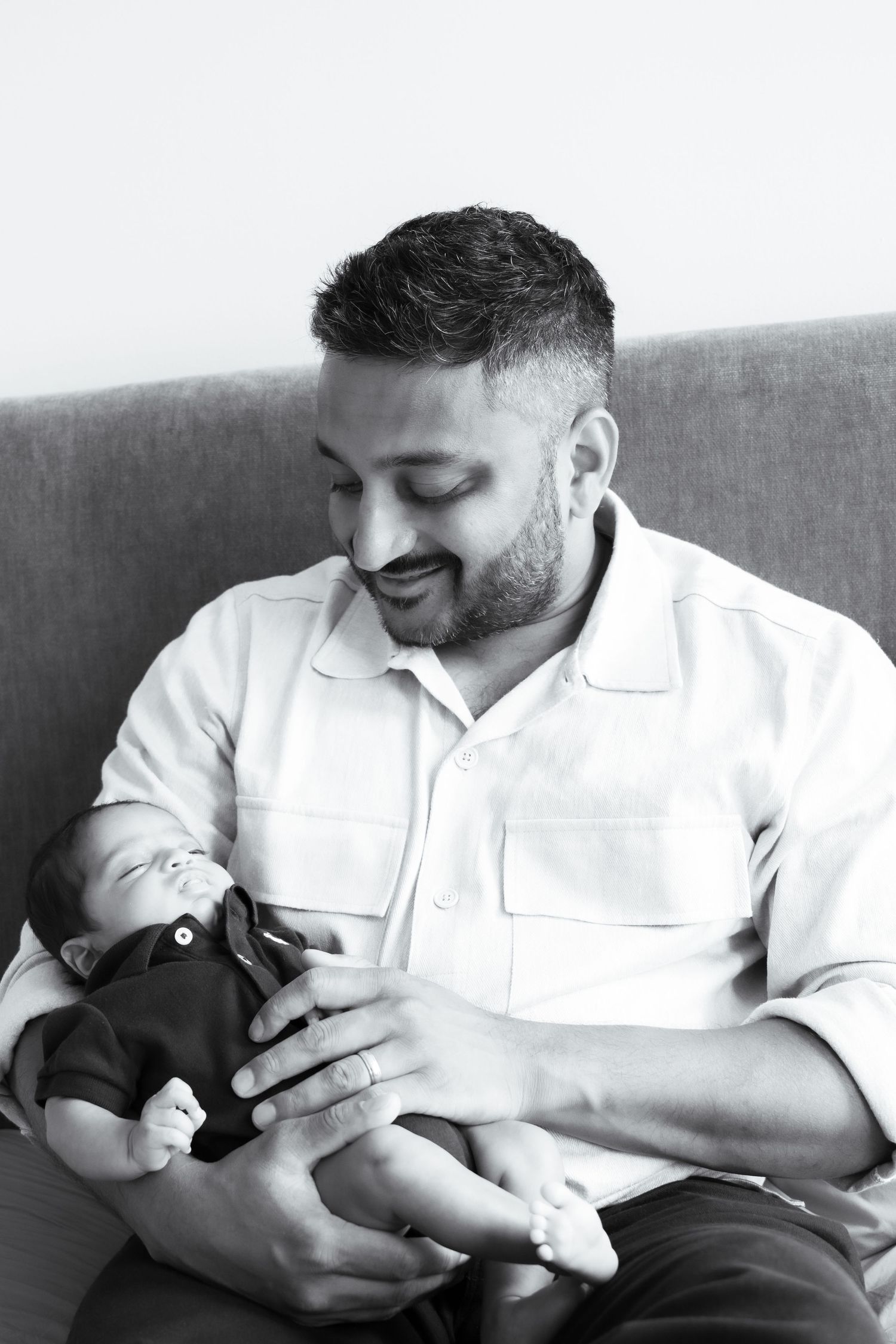 Tender moments between parent and newborn baby in black and white photography.