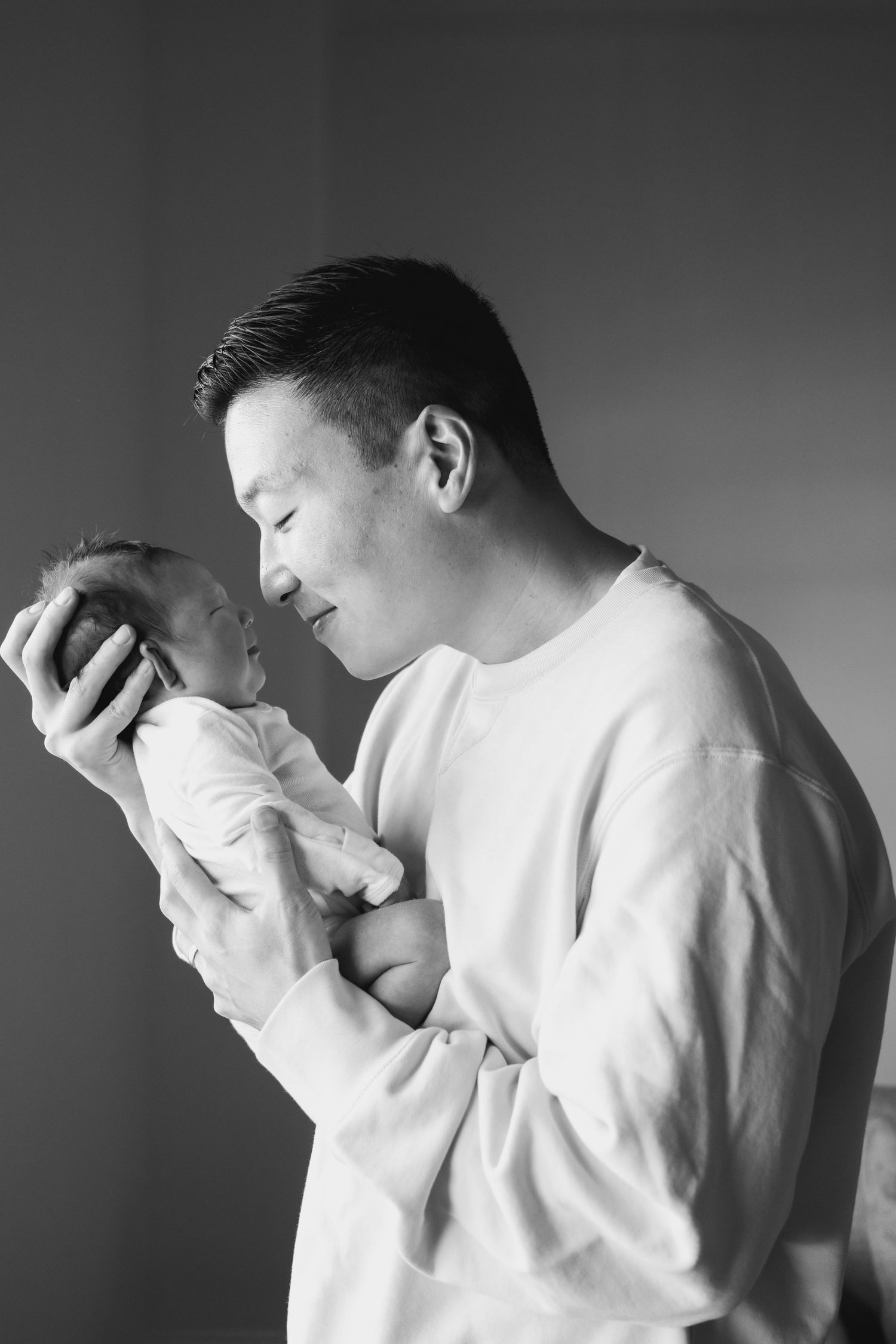 Black and white portraits showing tender parent and baby moments.