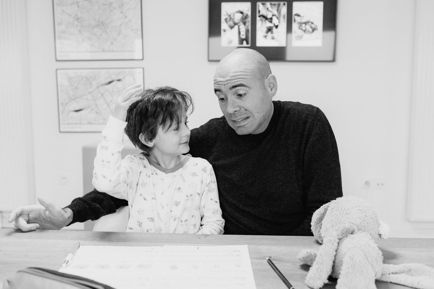 Une série de photos en noir et blanc montrant des instants tendres entre un adulte et un enfant partageant dessins et histoires..