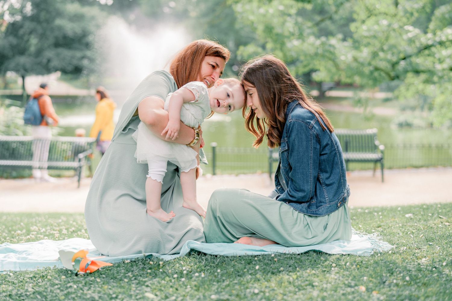 Young couple lounges together on a grassy lawn at a park during an intimate outdoor photo session.