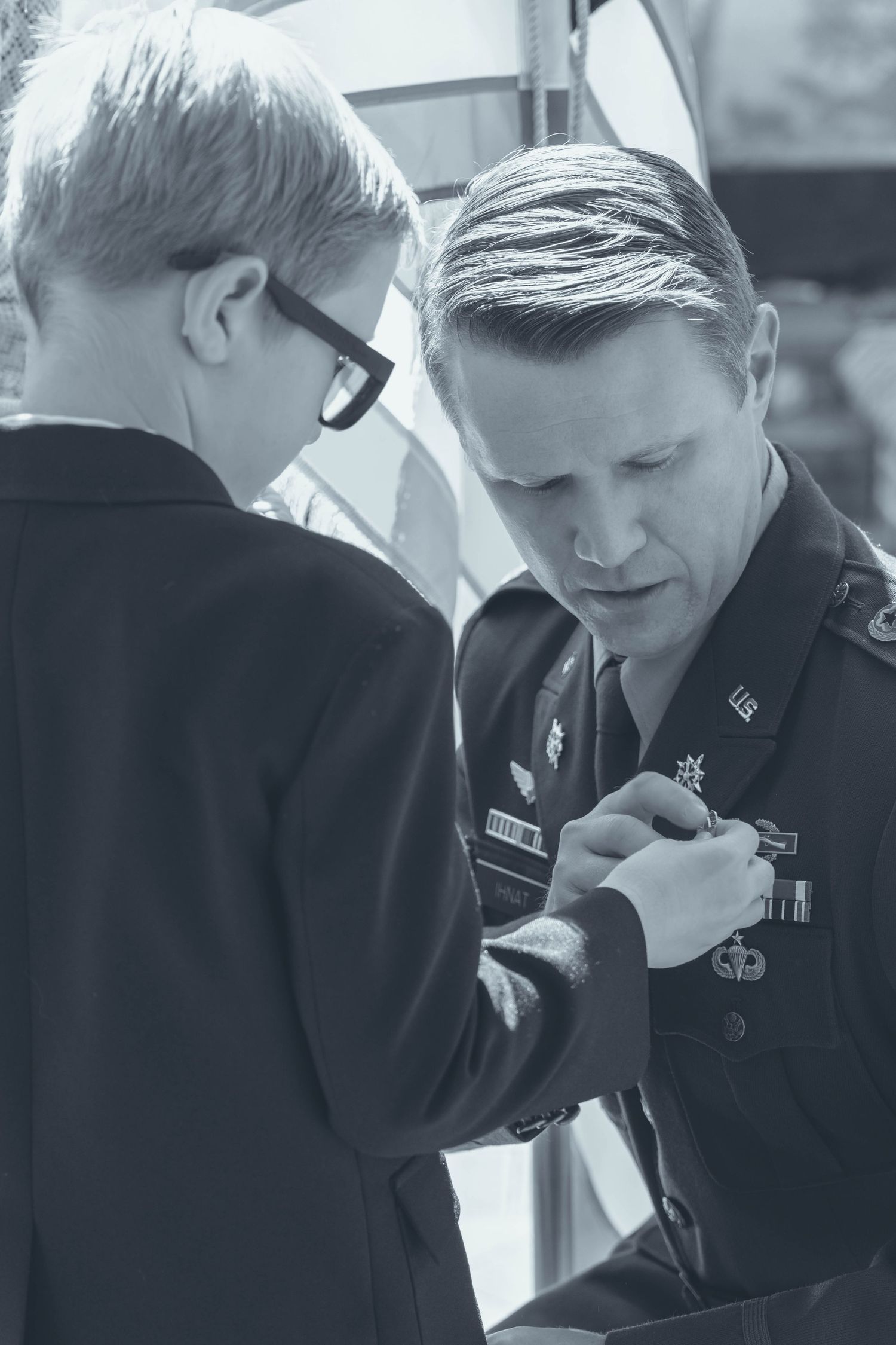 A black and white photo sequence shows a person in formal attire looking down while working at a desk.