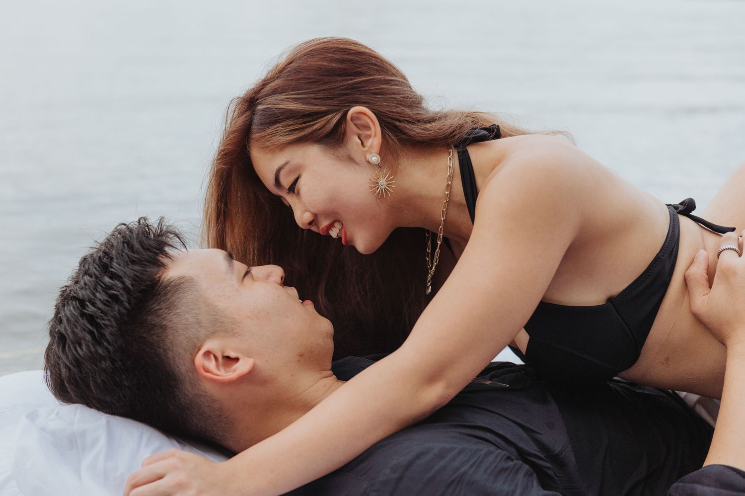 Romantic couple embraces intimately on a bed during a romantic moment.