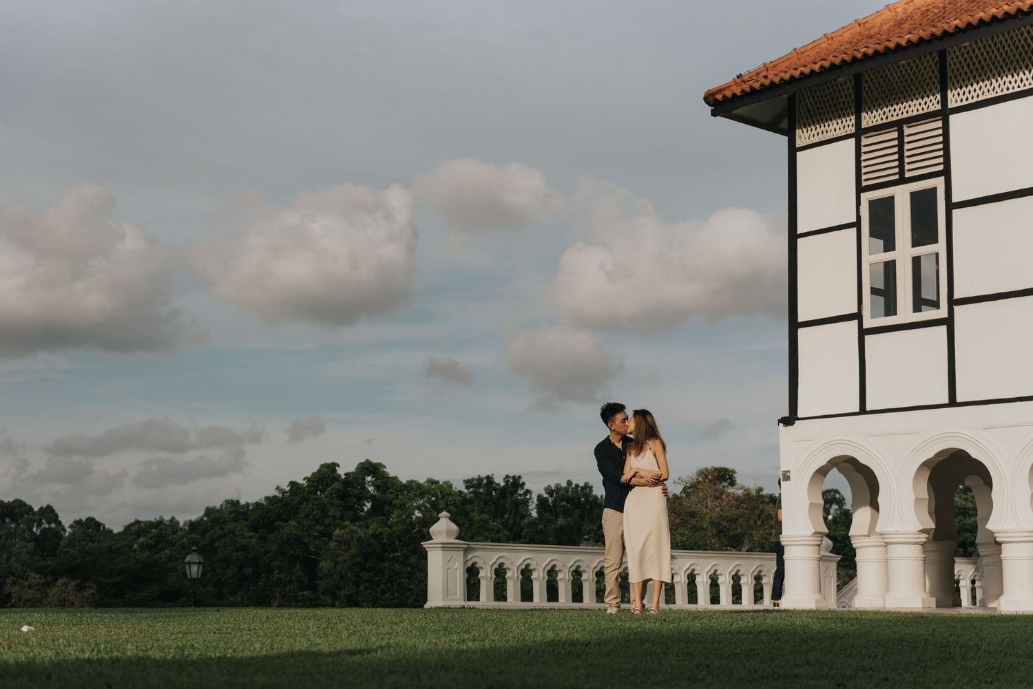 Romantic scene in front of a colonial mansion with dramatic cloudy sky backdrop.