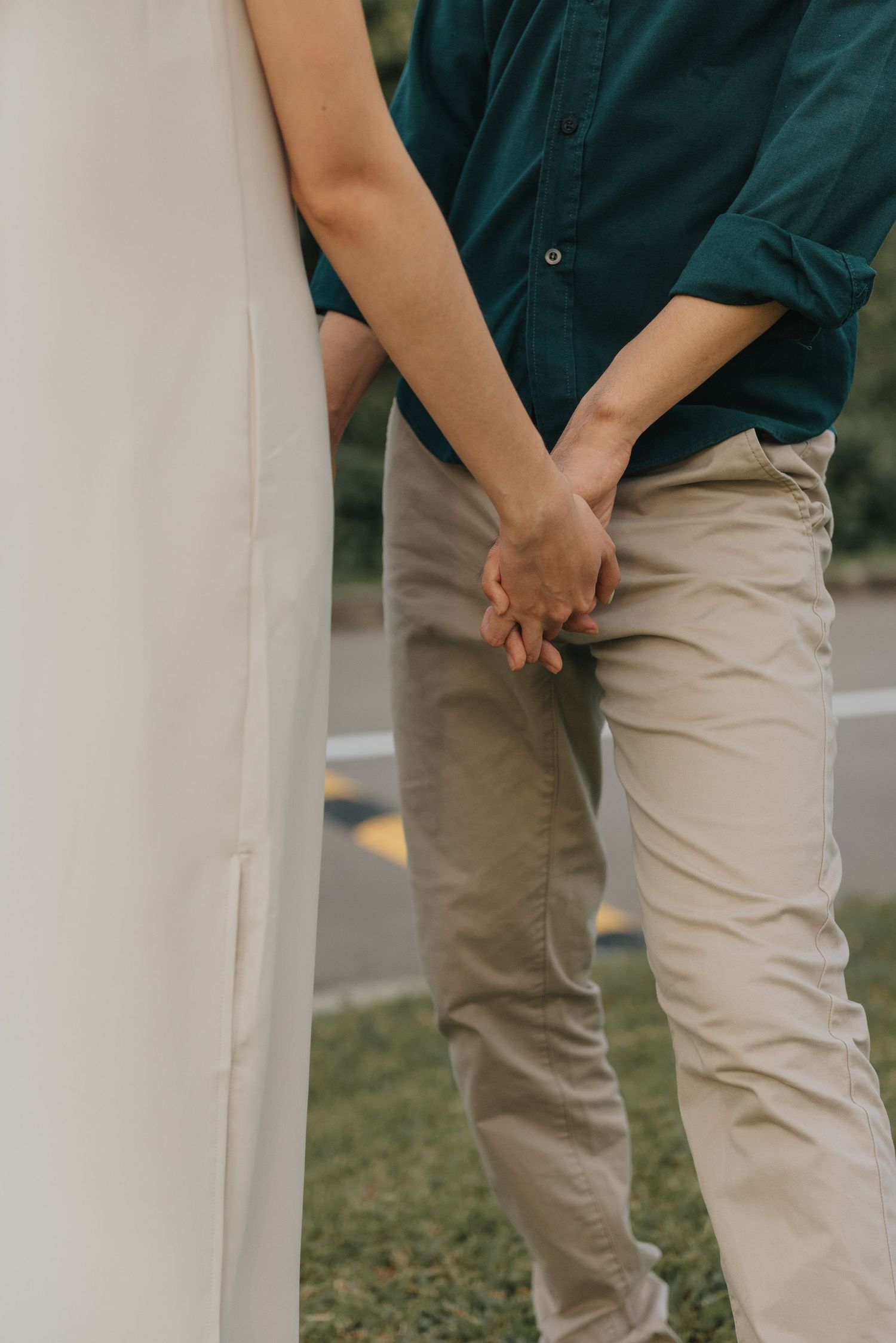Close up view of two people standing by a white pillar outdoors.
