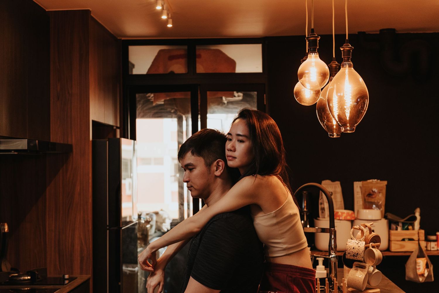 A cozy indoor scene with pendant lighting and warm atmospheric tones.