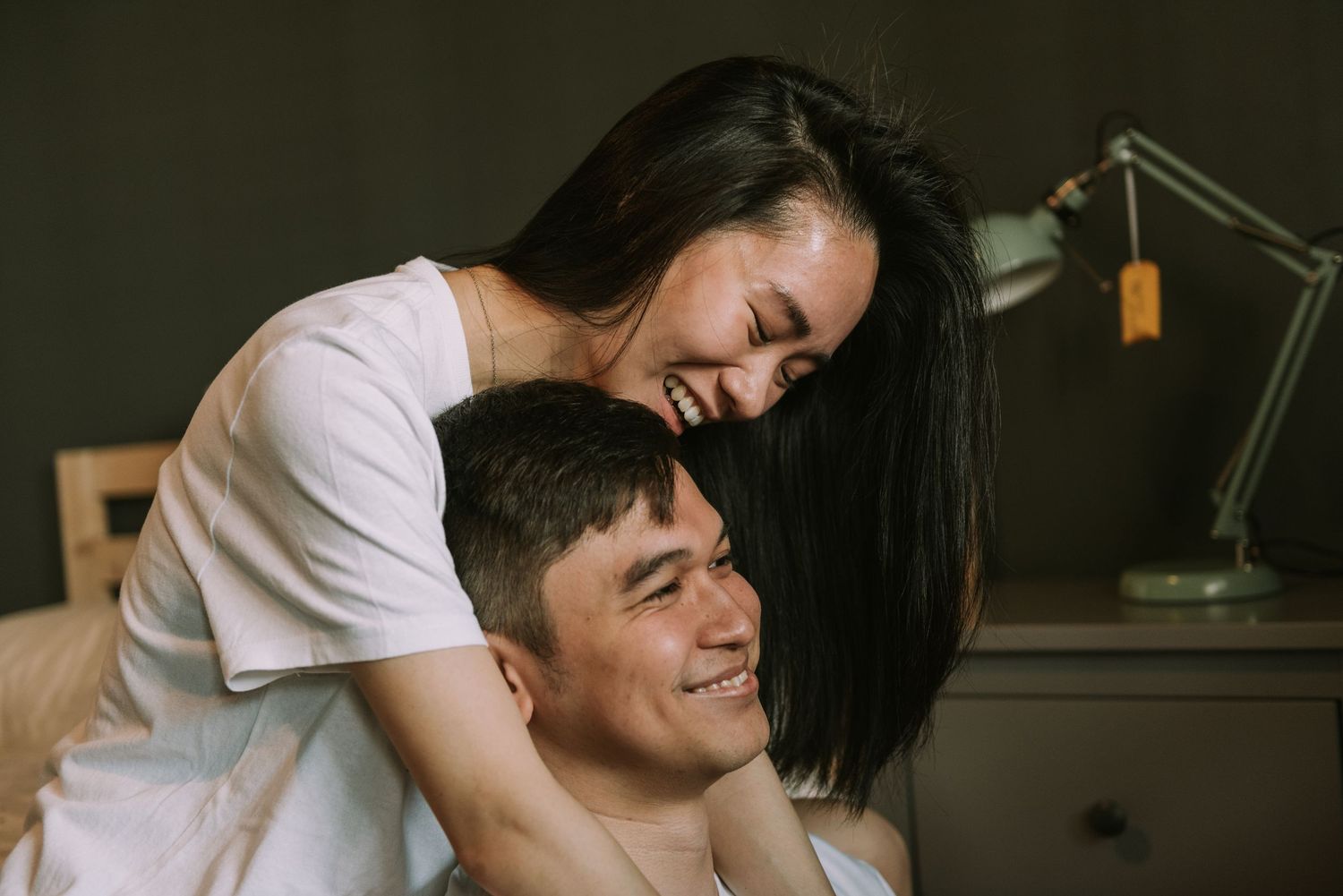Couple sharing joyful moment together during indoor photoshoot.
