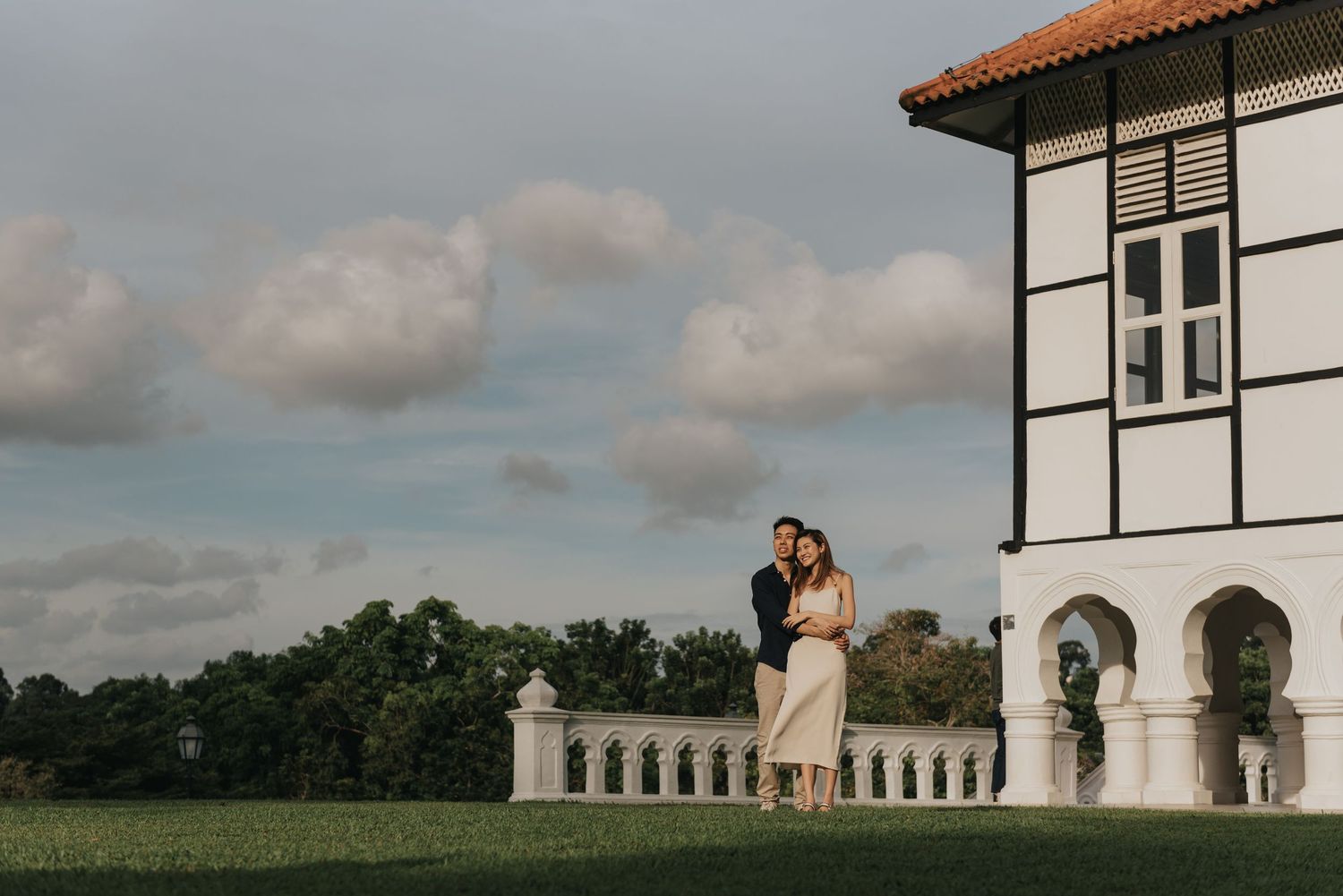 Elegant architectural portrait with colonial building and dramatic cloud formations.