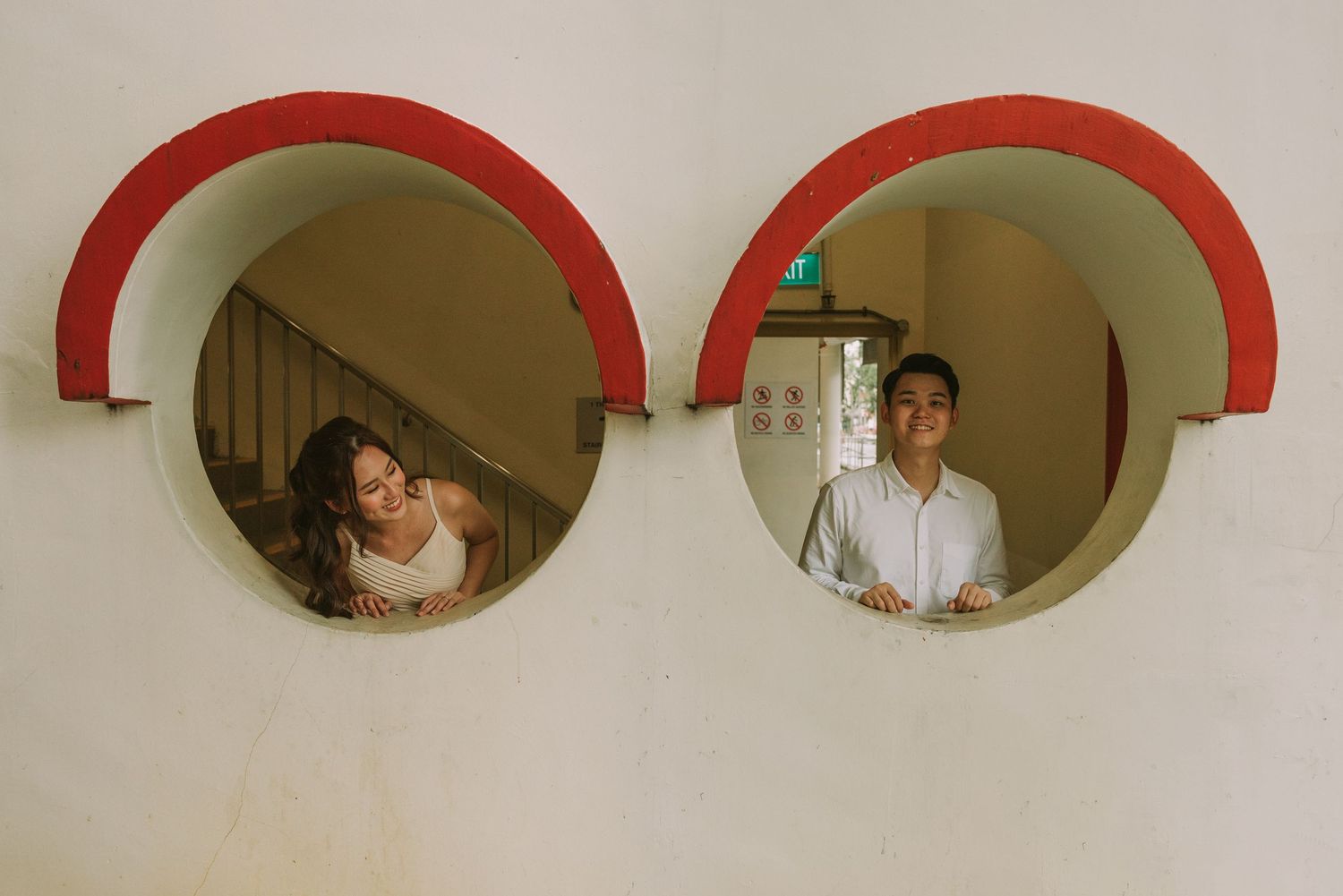 Creative photo composition using round red-rimmed mirrors reflecting intimate portraits.