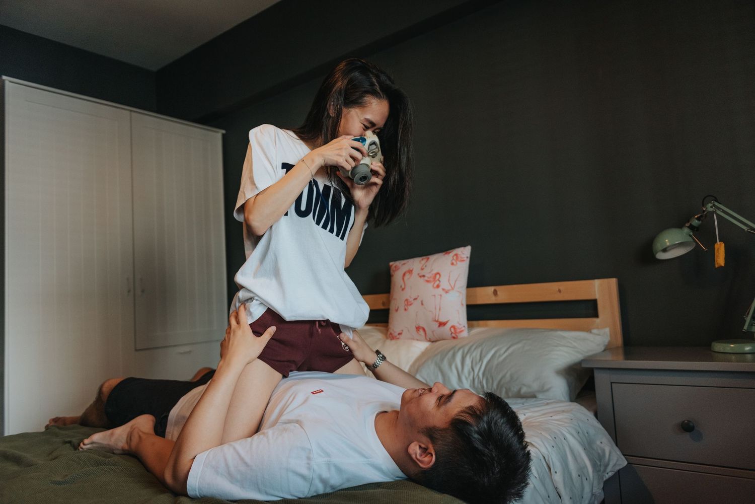 Candid moment between couple during a casual indoor photoshoot with vintage furniture.