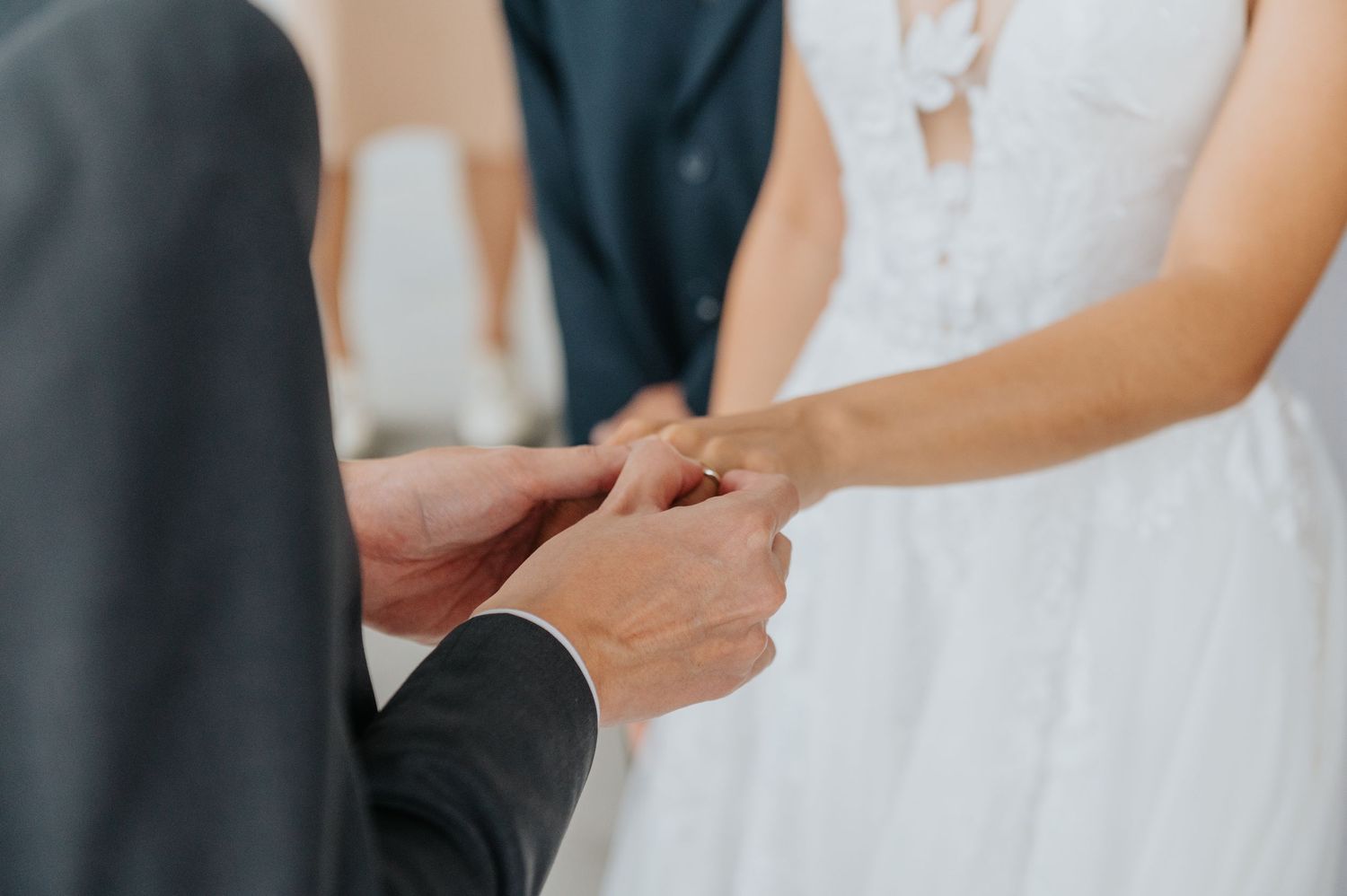 Closeup of hands exchanging business cards with text against a blurred background.