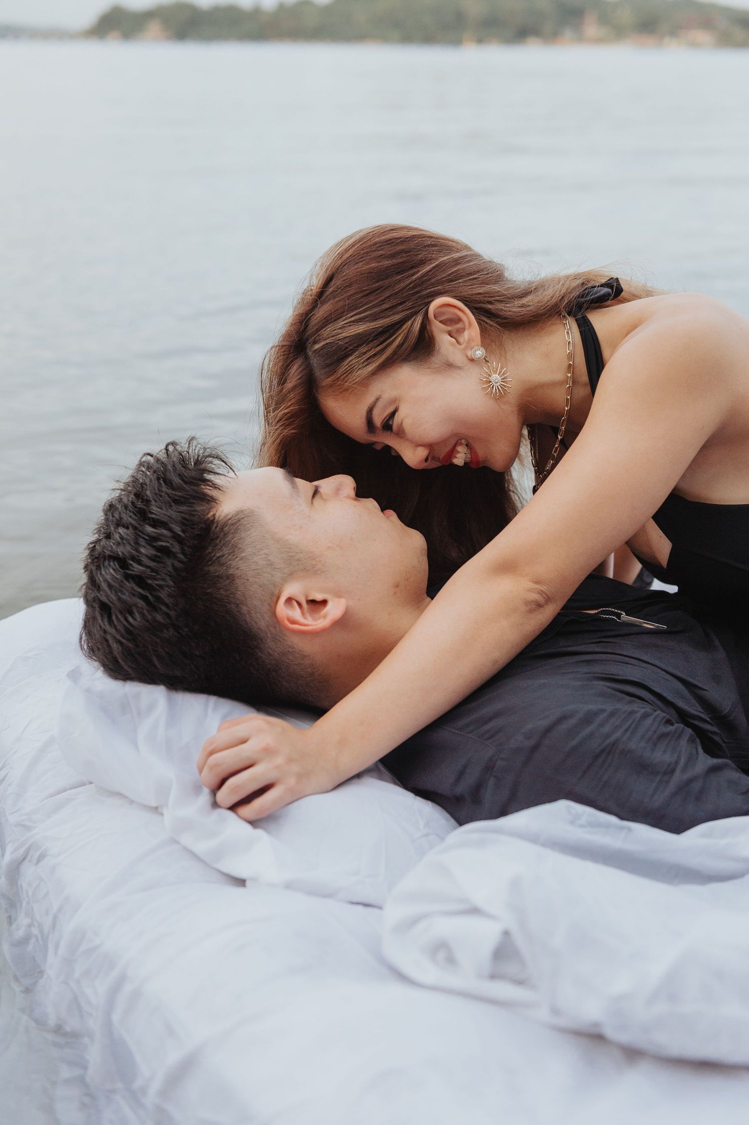 Tender moment captured between couple on floating mattress in lake setting.