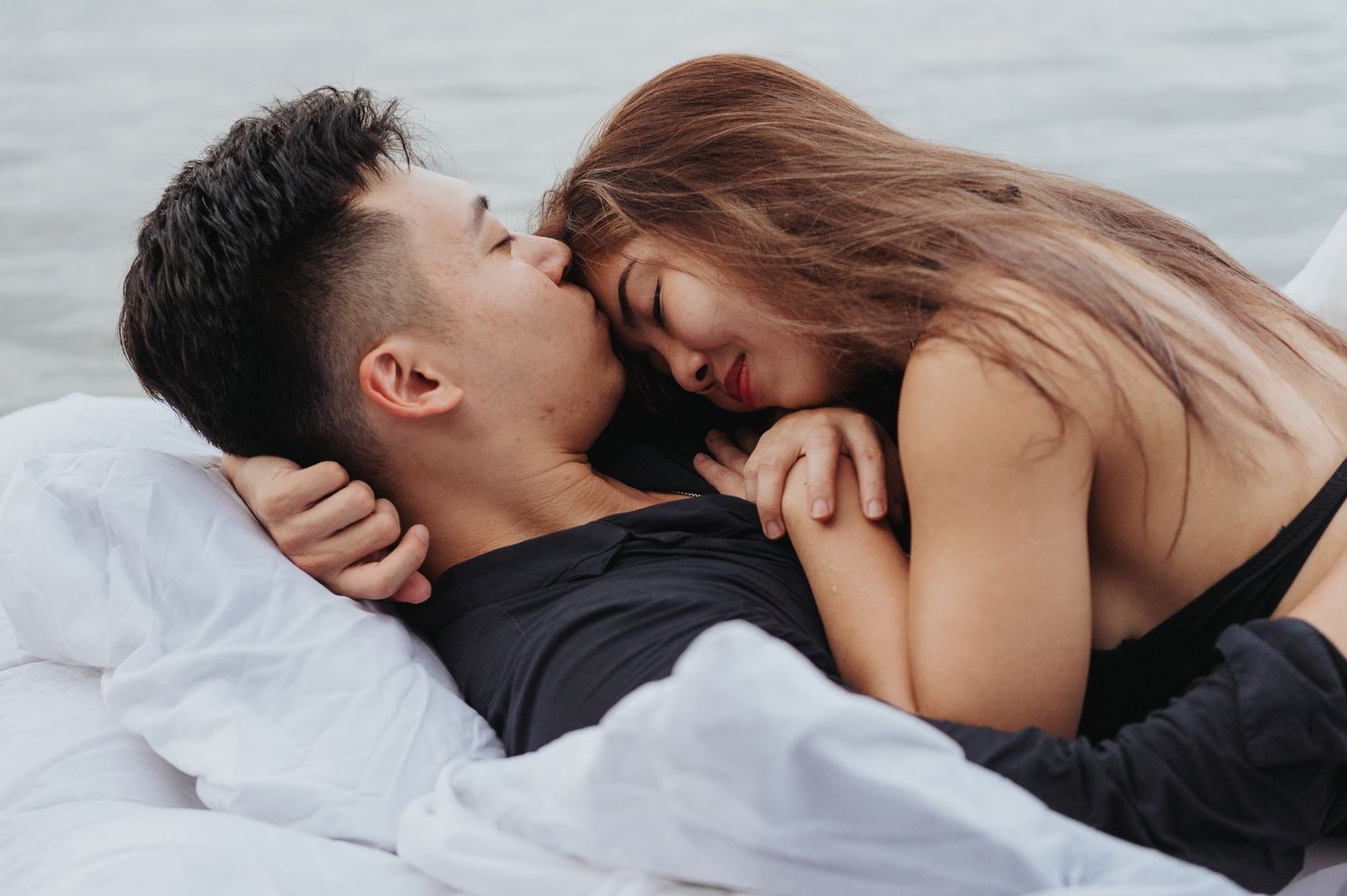 Intimate lakeside photoshoot featuring couple on floating mattress.