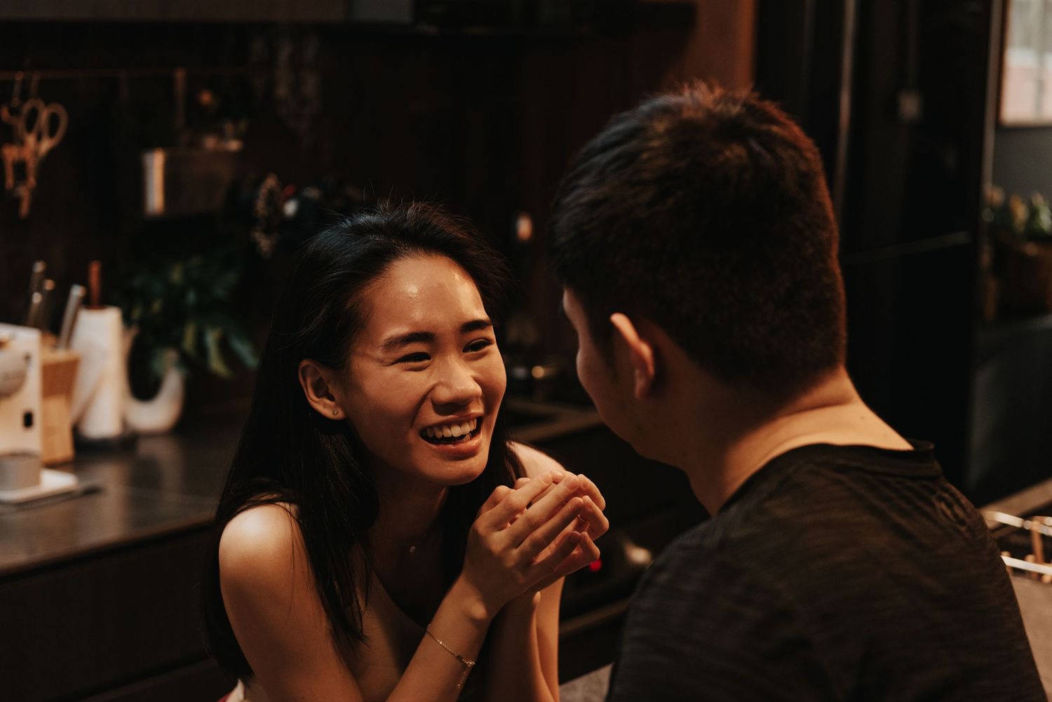 A candid moment of joy captured in a dimly lit restaurant setting.