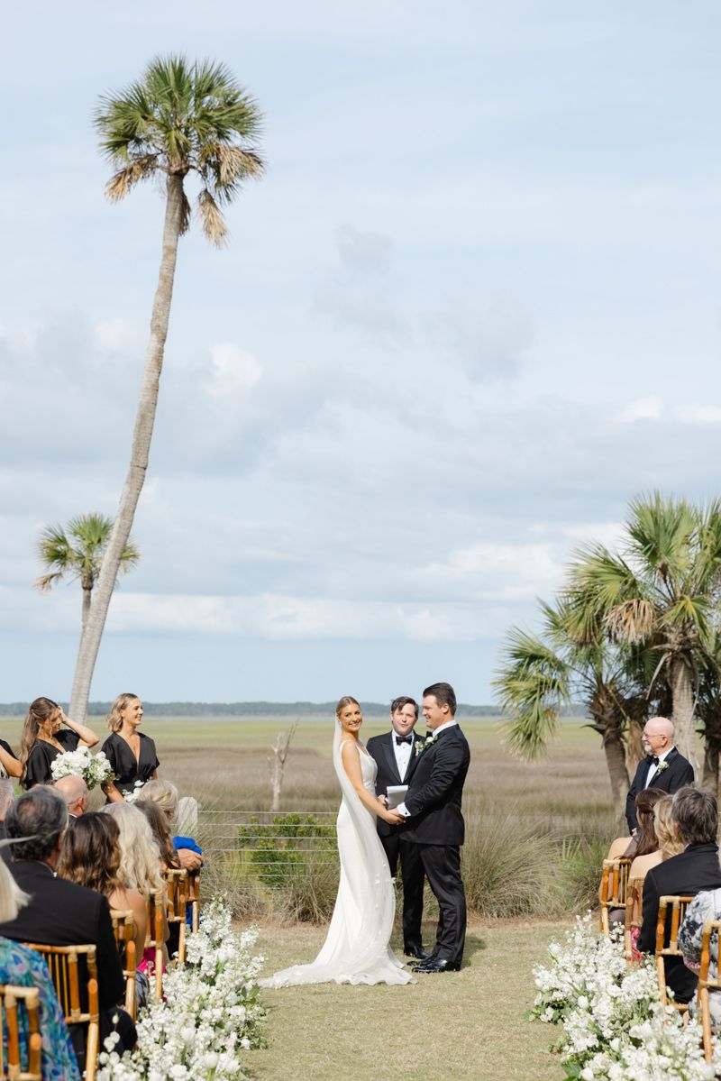 Wedding ceremony with marshside views at Forbes Farm, St. Simons Island. Scenic outdoor venue setting.