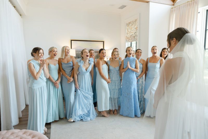 Excited bride reveals her look to bridesmaids in the bridal suite at Forbes Farm, St. Simons Island. Candid wedding moment.