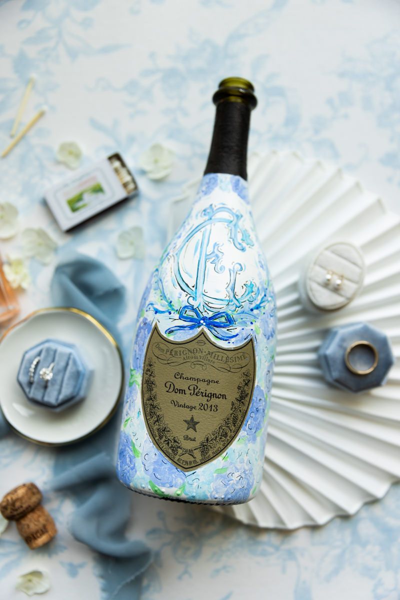 Custom painted champagne bottle in bride’s lay flat. Wedding details from Jekyll Island, Georgia.