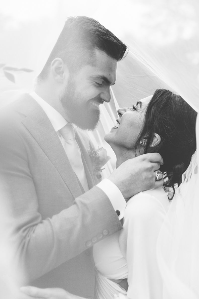 Bride and groom laughing under veil at Jekyll Island wedding, candid romantic photo inspo with film-style photography.